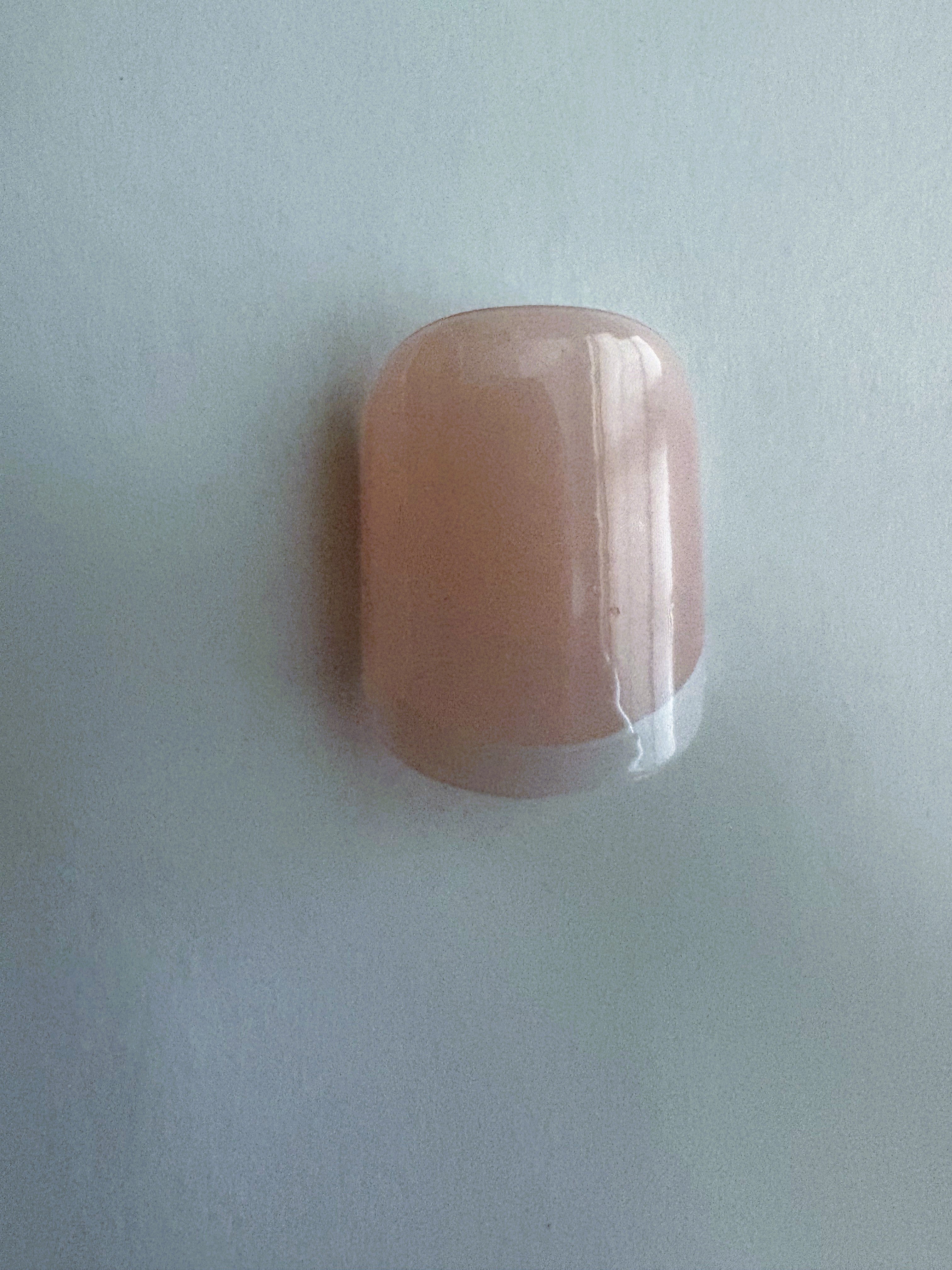 French nail tips and eyelash set on a light gray background