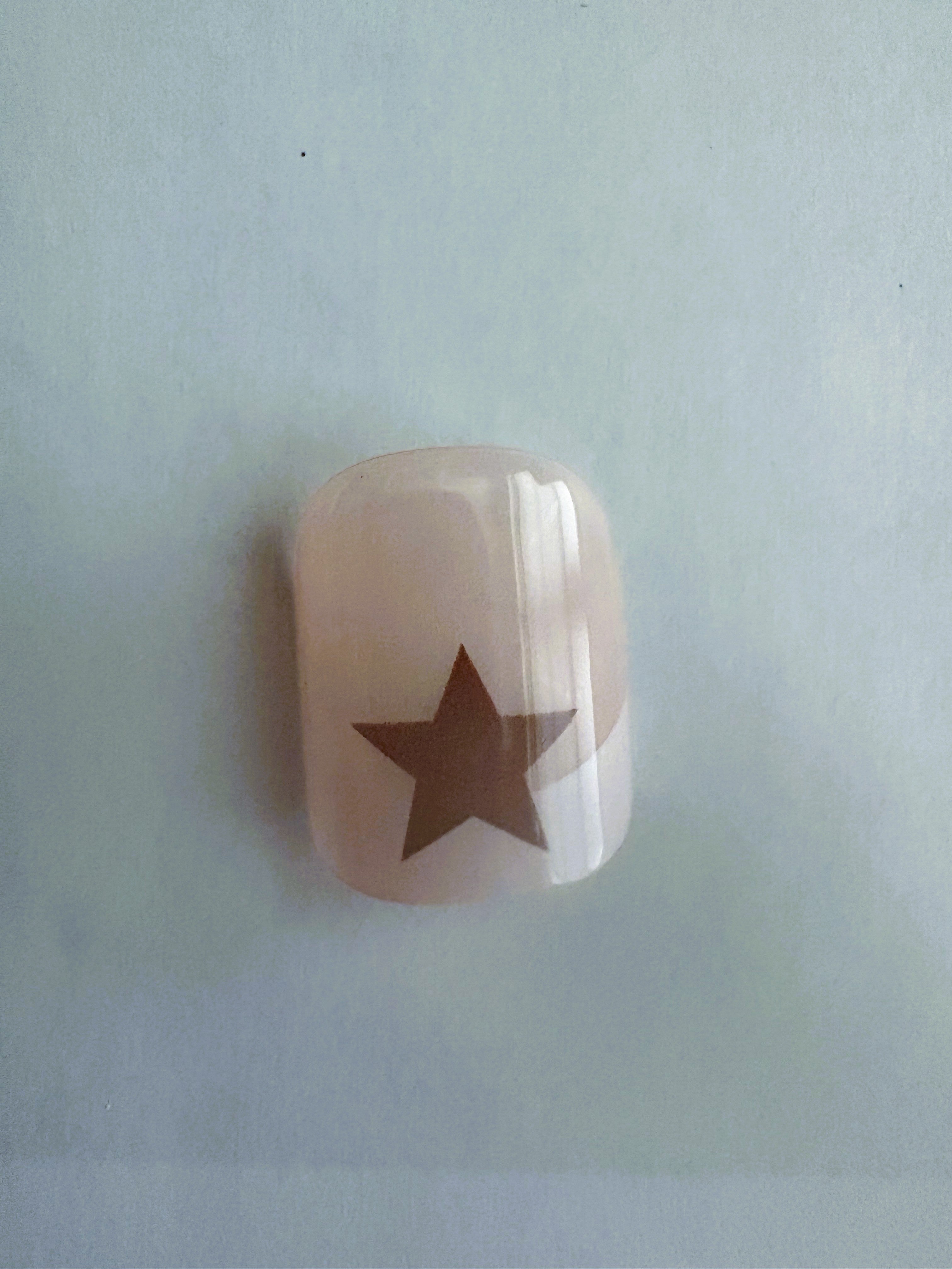 Short Nail with a star design and eyelash set on a light blue background